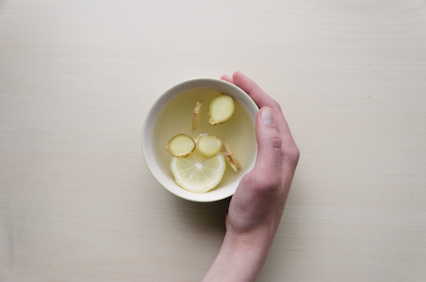 a woman's hand holding a cup of tea