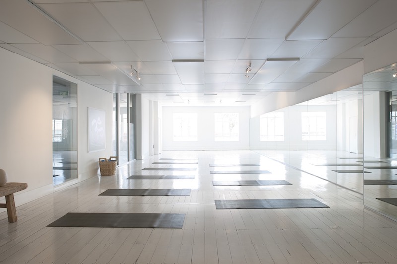 empty light-filled yoga studio with mats layed out